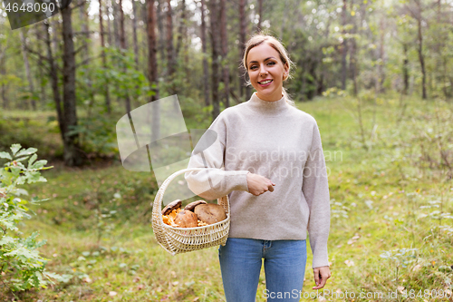 Image of woman with basket picking mushrooms in forest