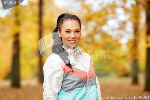 Image of young woman in sports clothing at autumn park