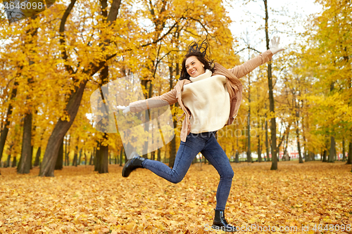 Image of beautiful happy young woman in autumn park