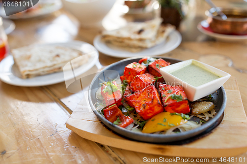 Image of close up of paneer tikka dish with sauce on table