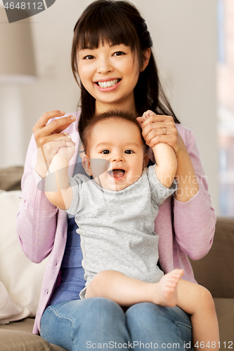 Image of happy young mother with little baby son at home