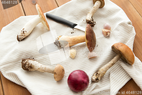 Image of edible mushrooms, kitchen knife and towel
