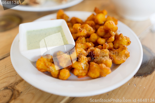 Image of close up of cauliflower pakora with dip sauce