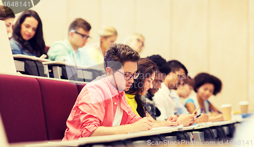 Image of group of students with notebooks in lecture hall