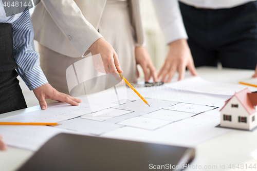 Image of close up of architects with blueprint at office