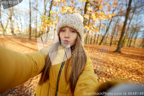 Image of girl taking selfie making duck face at autumn park