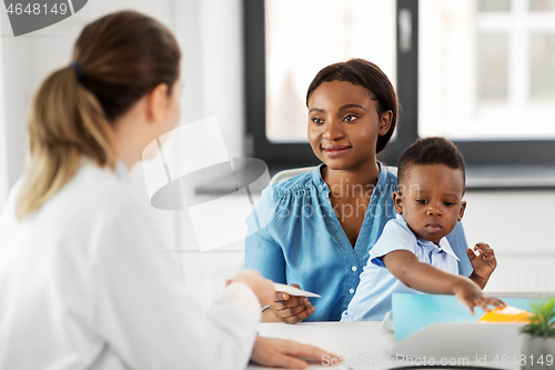 Image of happy mother with baby son and doctor at clinic