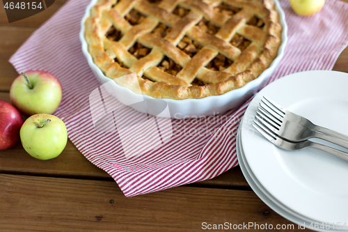 Image of apple pie in baking mold on wooden table