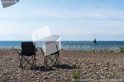 Image of Two chairs by the coast