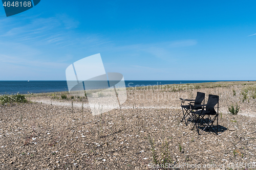 Image of Summer view with two empty chairs by the coast