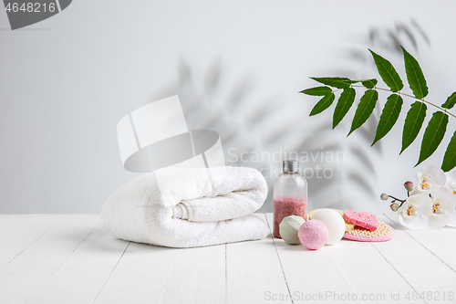 Image of Beautiful spa composition on massage table in wellness center, copyspace. Leaves\' shadows on the wall