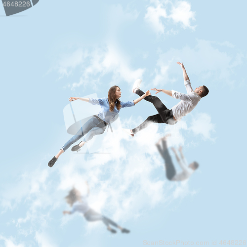 Image of Mid-air beauty. Full length studio shot of attractive young woman and man hovering in air and keeping eyes closed