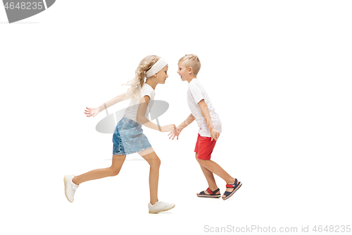 Image of Happy little caucasian girl and boy jumping and running isolated on white background