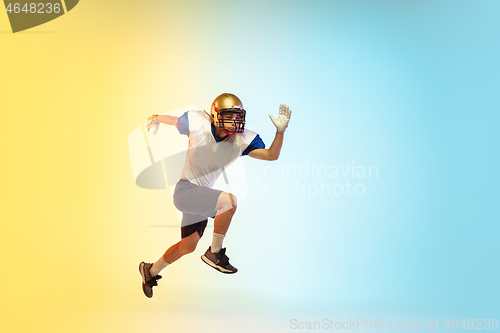 Image of American football player isolated on gradient studio background in neon light