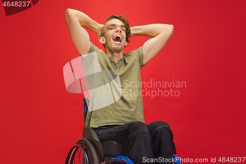 Image of Caucasian young man\'s portrait isolated on red studio background. Human emotions concept