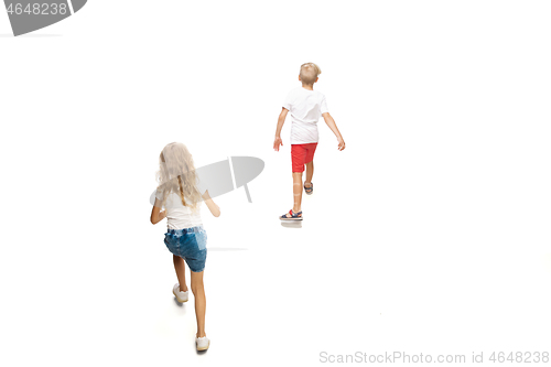 Image of Happy little caucasian girl and boy jumping and running isolated on white background