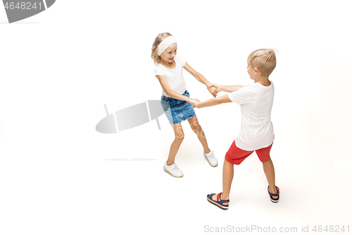 Image of Happy little caucasian girl and boy jumping and running isolated on white background