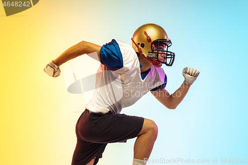 Image of American football player isolated on gradient studio background in neon light