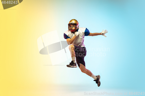 Image of American football player isolated on gradient studio background in neon light