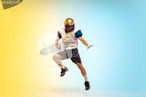 Image of American football player isolated on gradient studio background in neon light