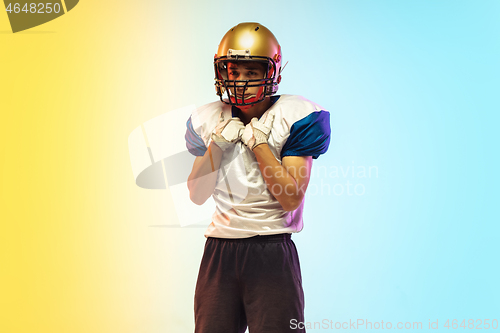 Image of American football player isolated on gradient studio background in neon light
