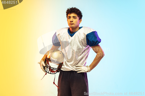 Image of American football player isolated on gradient studio background in neon light