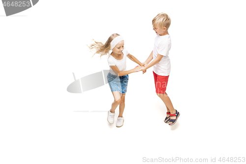 Image of Happy little caucasian girl and boy jumping and running isolated on white background