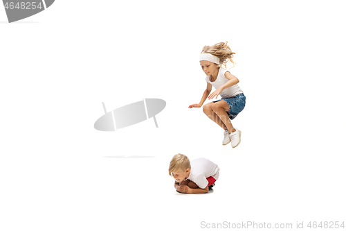 Image of Happy little caucasian girl and boy jumping and running isolated on white background