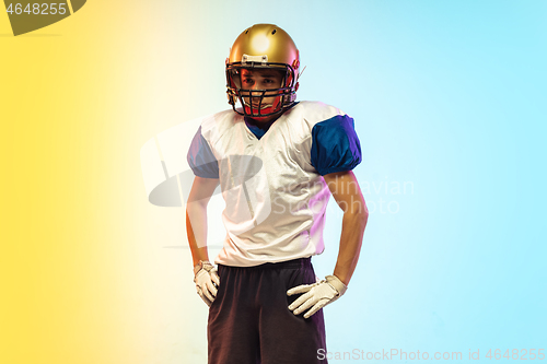 Image of American football player isolated on gradient studio background in neon light