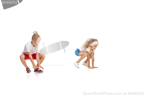 Image of Happy little caucasian girl and boy jumping and running isolated on white background