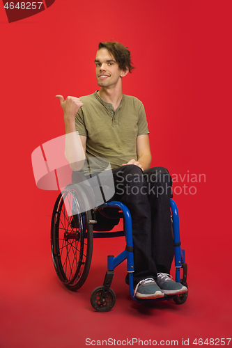 Image of Caucasian young man\'s portrait isolated on red studio background. Human emotions concept