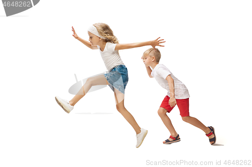 Image of Happy little caucasian girl and boy jumping and running isolated on white background