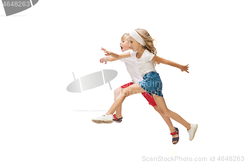 Image of Happy little caucasian girl and boy jumping and running isolated on white background