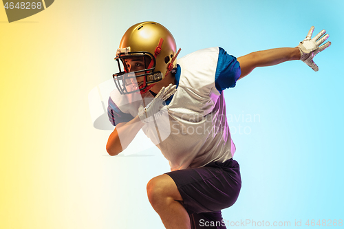 Image of American football player isolated on gradient studio background in neon light