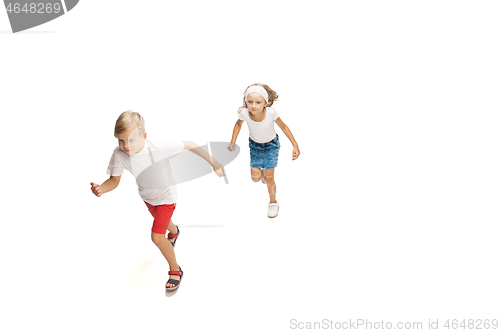 Image of Happy little caucasian girl and boy jumping and running isolated on white background