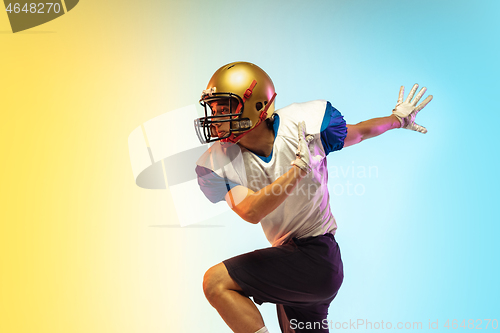 Image of American football player isolated on gradient studio background in neon light