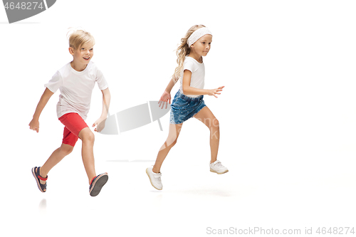 Image of Happy little caucasian girl and boy jumping and running isolated on white background