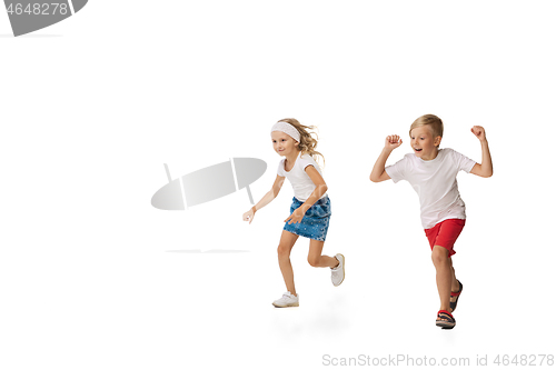 Image of Happy little caucasian girl and boy jumping and running isolated on white background