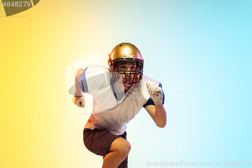 Image of American football player isolated on gradient studio background in neon light