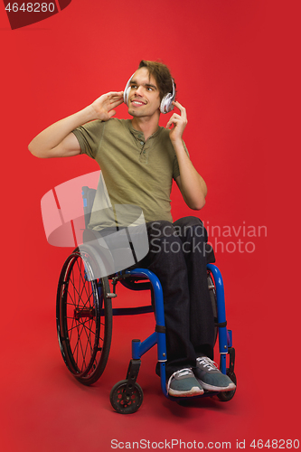 Image of Caucasian young man\'s portrait isolated on red studio background. Human emotions concept