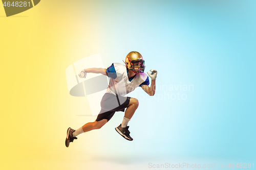 Image of American football player isolated on gradient studio background in neon light