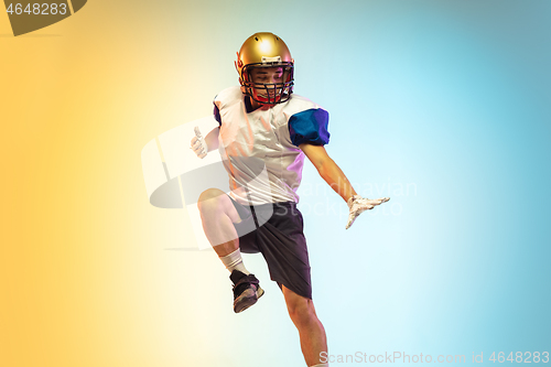 Image of American football player isolated on gradient studio background in neon light