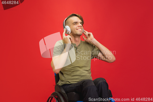 Image of Caucasian young man\'s portrait isolated on red studio background. Human emotions concept