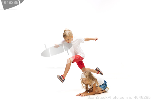 Image of Happy little caucasian girl and boy jumping and running isolated on white background