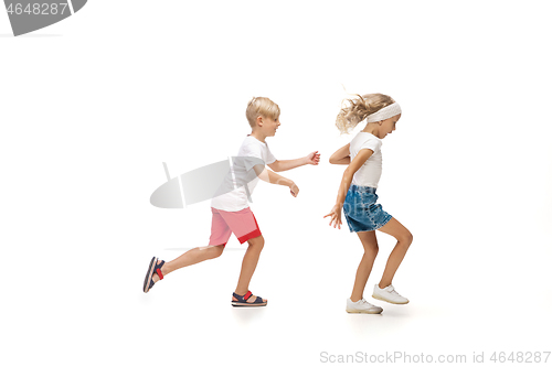 Image of Happy little caucasian girl and boy jumping and running isolated on white background