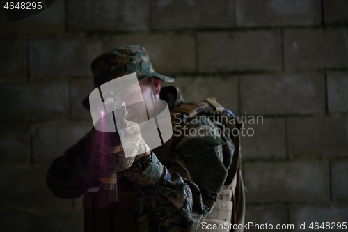 Image of soldier in action aiming  on laser sight optics