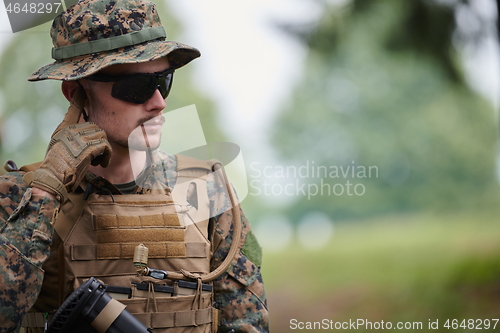 Image of soldier preparing tactical and commpunication gear for action ba