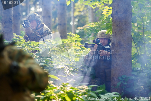 Image of soldier in action aiming  on laser sight optics