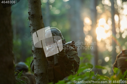 Image of soldier in action aiming  on weapon  laser sight optics