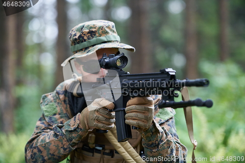 Image of soldier in action aiming  on weapon  laser sight optics